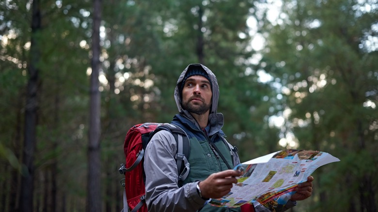 Hiker holding map and looking lost