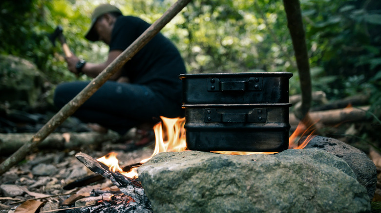 Campfire man chops wood