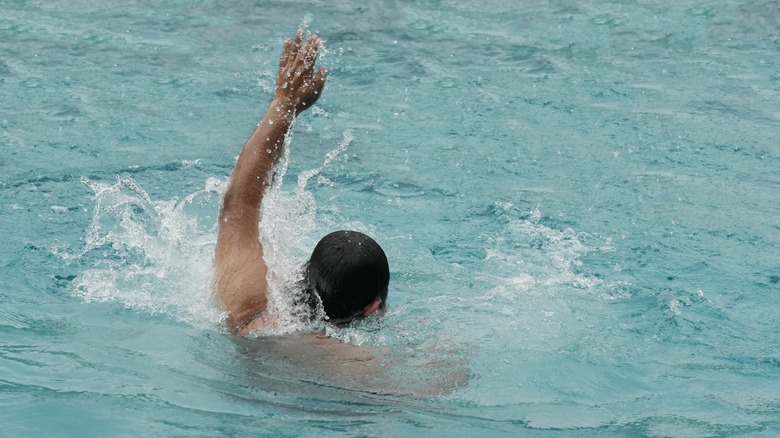 Man drowning raising left hand