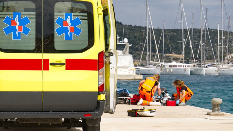 Paramedics performing first aid on person near port