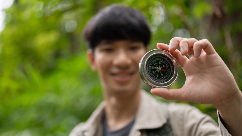 Hiker with compass, smiling