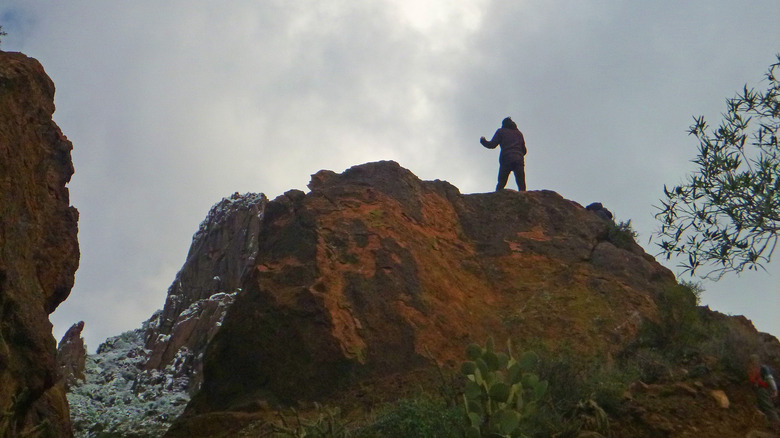 Hiker standing on hilltop, near Lost Dutchman Mine