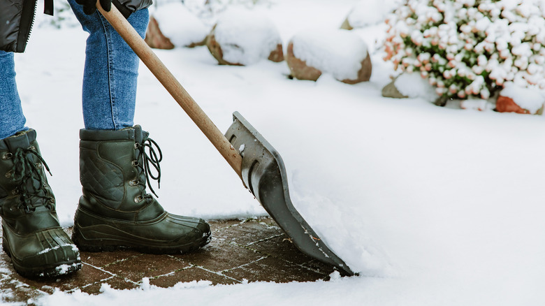 Woman shoveling in snow boots