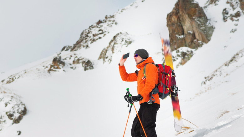 Skier with phone on mountain