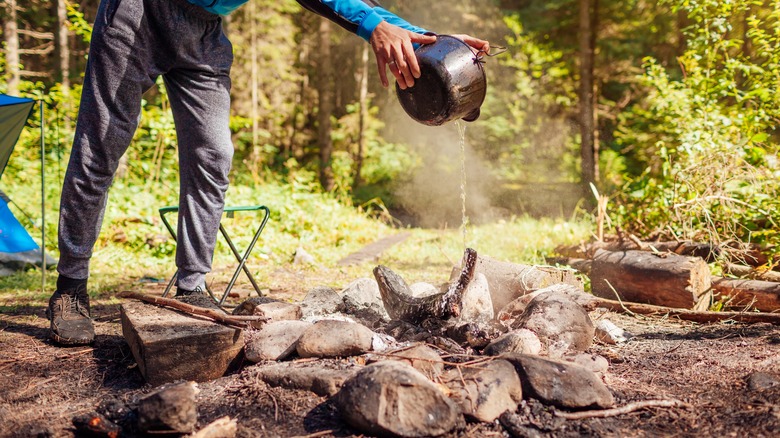 Person extinguishing fire with bucket of water