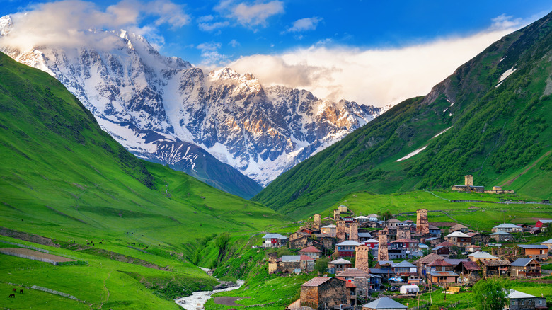 Village in valley below snow-capped mountains