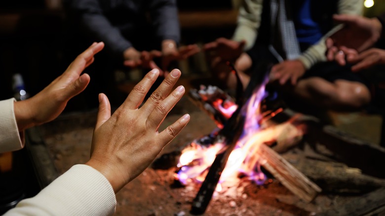 Warming hands around the fire