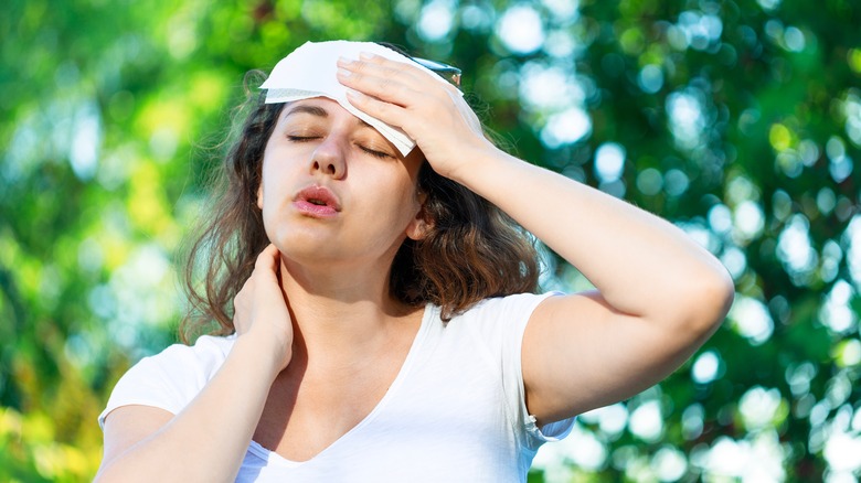 woman wiping off sweat outside