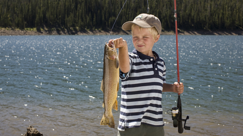Boy holding a fishing pole and fish