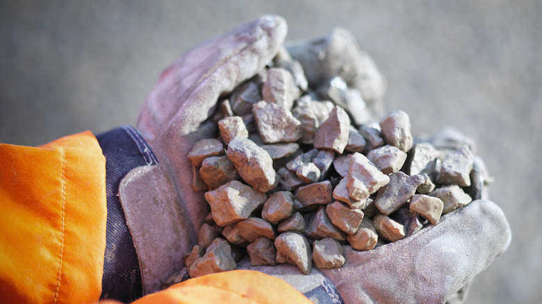 Person wearing gloves and holding gravel