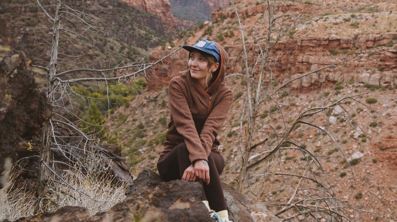 Kristen May seated outside on log in Utah