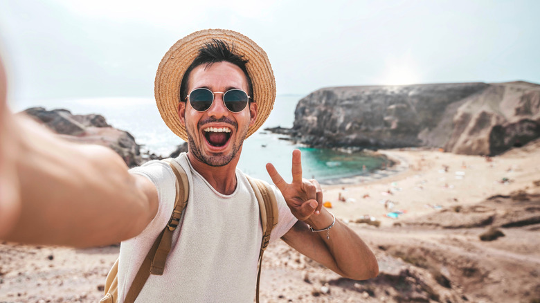 Man on a beach striking a pose for the camera like many outdoor influencers do