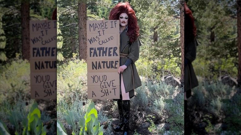 Pattiegonia holding a handmade sustainability sign in forest