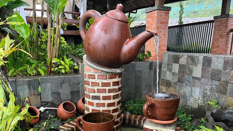 Tea pot fountain pouring water into cup