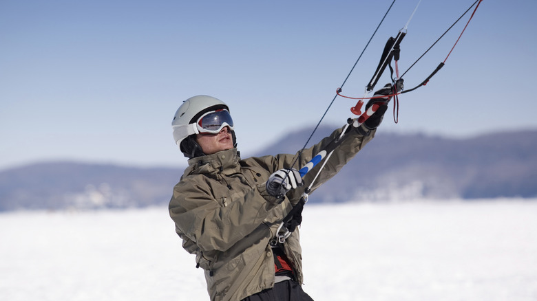 Snowkiter holding kite and looking up