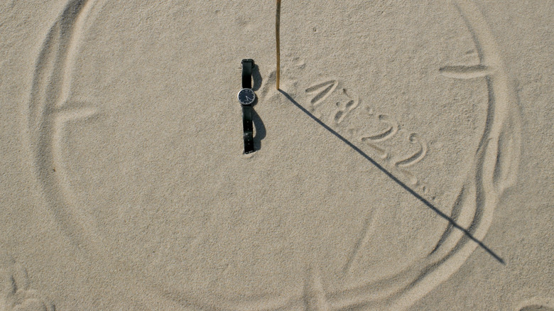 circle in sand with stick and shadows