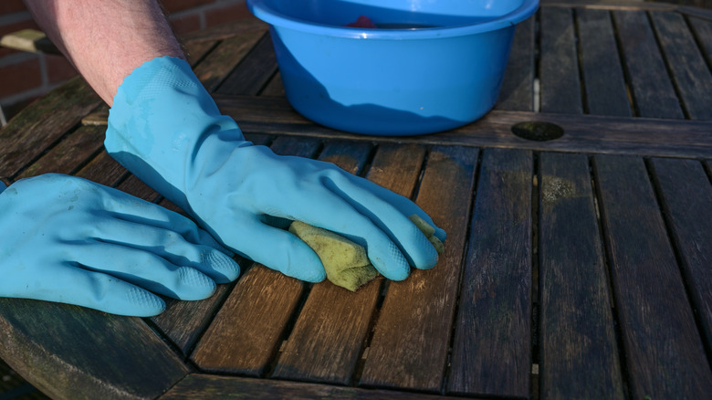 Hands cleaning patio deck 