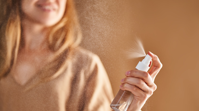 Woman spraying a liquid from spray bottle