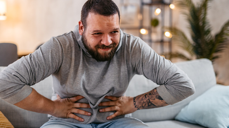 Man clutching stomach due to pain