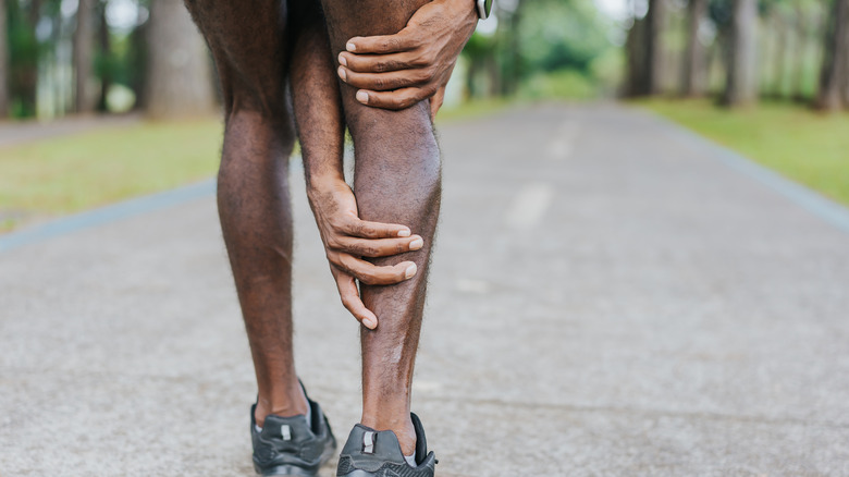Man clutching leg due to pain