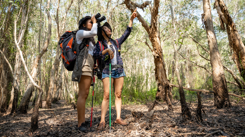 Two women birders with hiking gear and binoculars