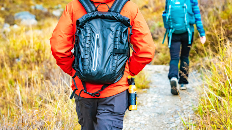 Hiker carrying bear spray on hip and walking