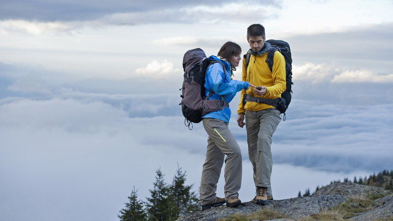 Two hikers using device