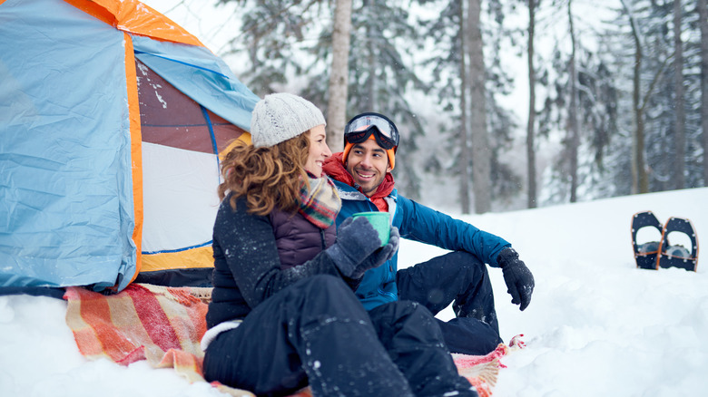 Man and woman camping in the snow