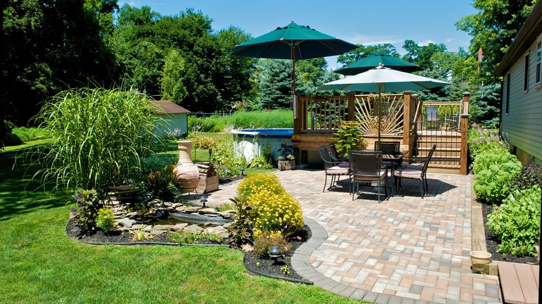 Brick patio in a sunny garden with green grass