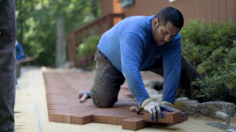 Man laying down bricks