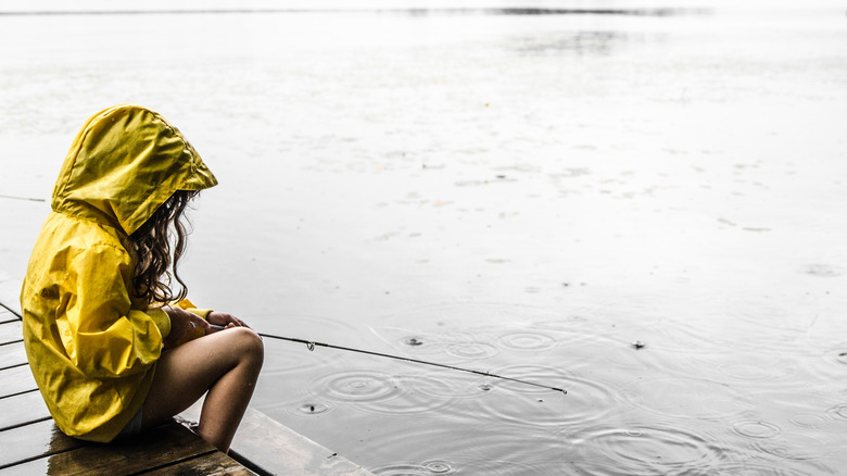 A little girl fishing in the rain