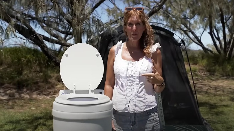 Woman pointing to dry flush toilet next to her