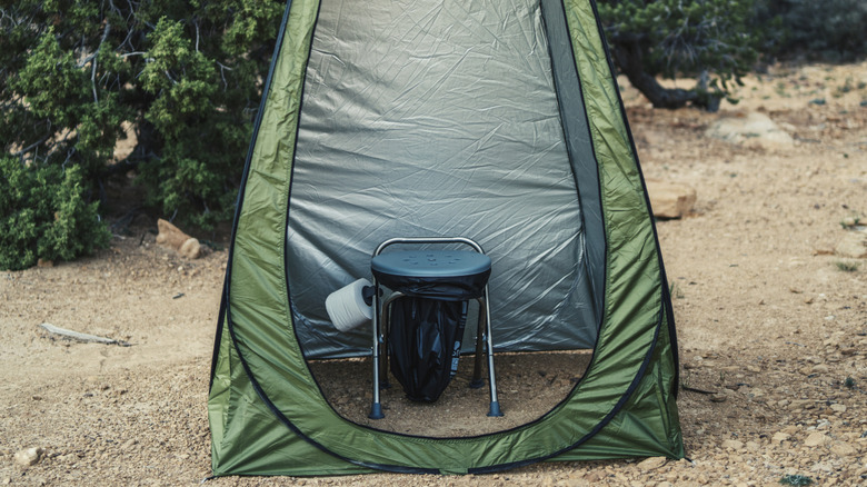 A very simple foldable camping toilet with bag set up in a toilet tent