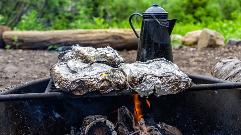 Foil wrapped food cooking over a fire