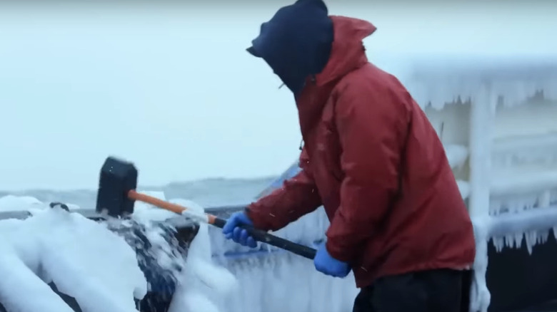  Man breaking ice on boat