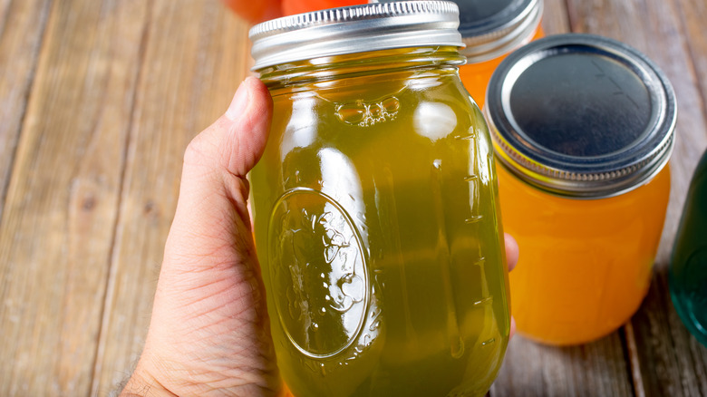 Hand holding jar of pickle juice