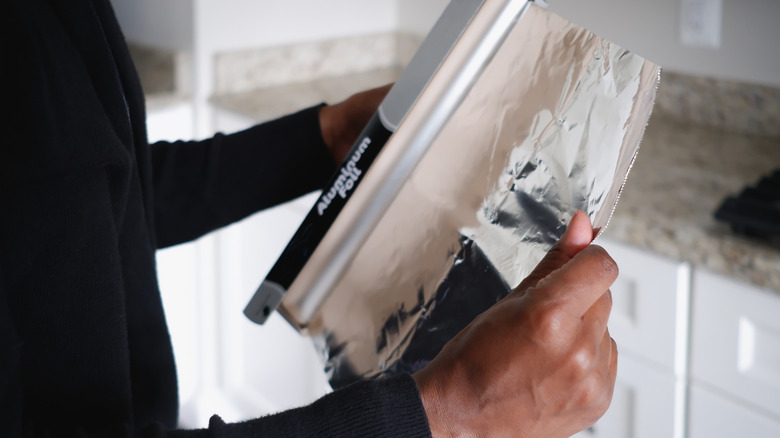 Man unolling aluminum foil