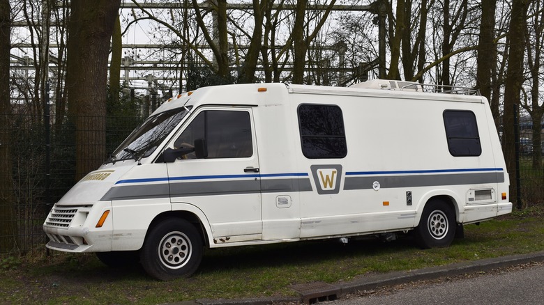 Classic camper from the 1980s in good condition parked near trees