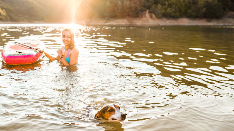 Person swimming with dog