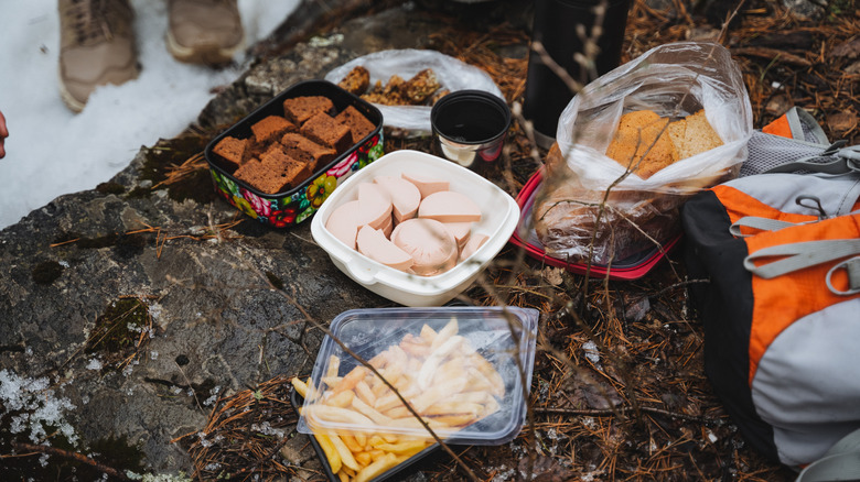 Various high-calorie snacks on a stone outside in winter