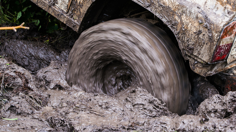 Car wheel spinning in mud