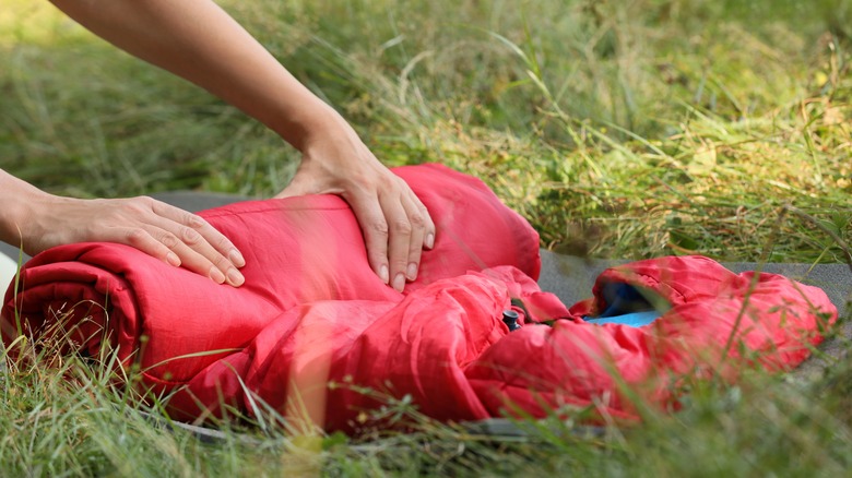 Rolling up red sleeping bag